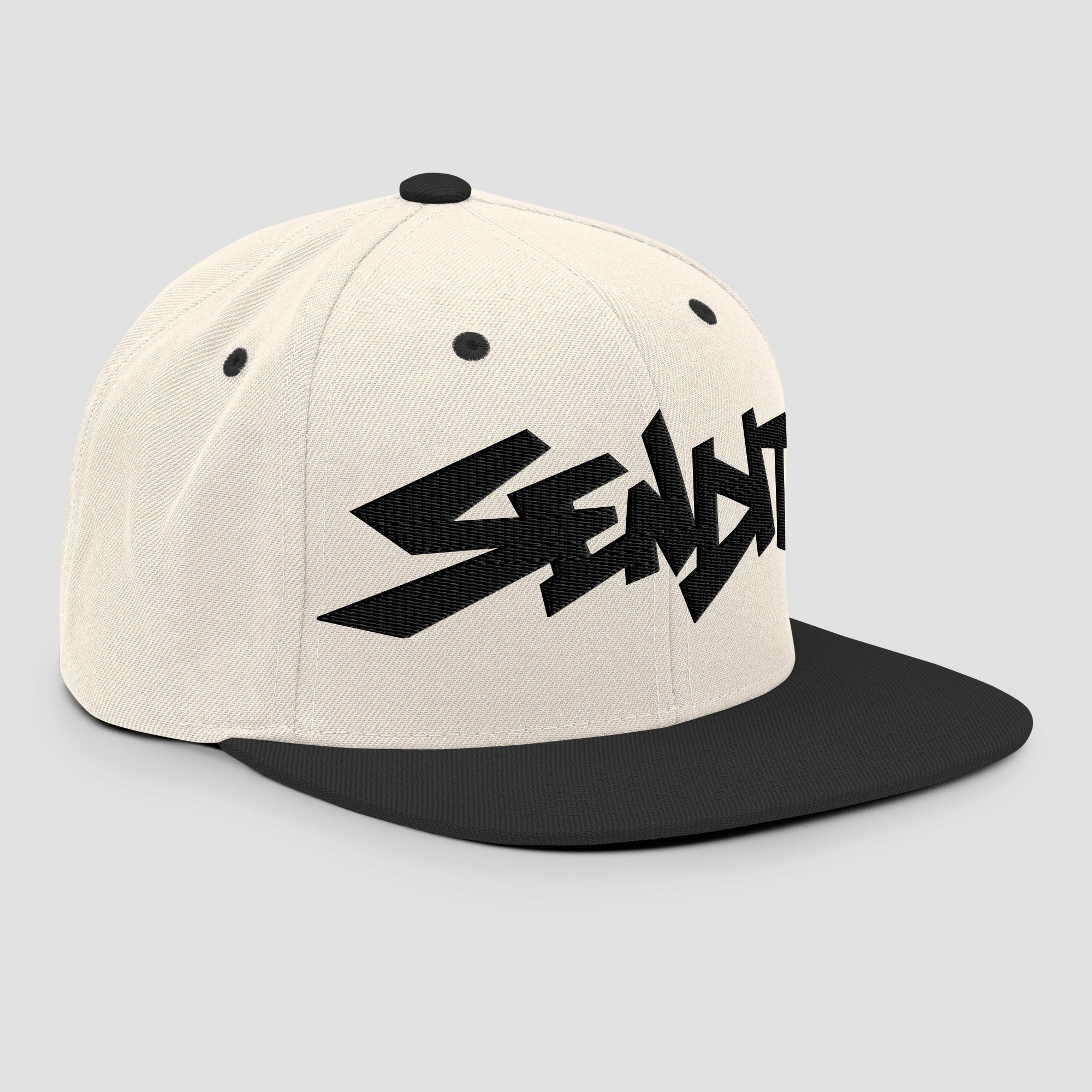 An off-white snapback cap with a black flat brim and a black embroidered stylized 'SENDIT' logo on the front, shown against a light gray background.