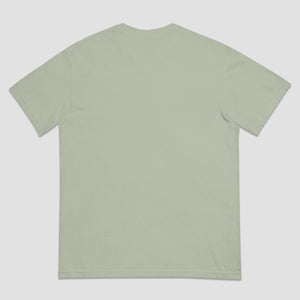 A light sage green short-sleeve t-shirt shown from the back, laid flat against a neutral light gray background.
