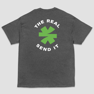 A dark gray heather short-sleeve t-shirt shown from the back, featuring a green and black logo with the text 'THE REAL SEND IT' centered around a green asterisk set on a light gray background.