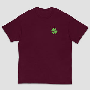 A maroon short-sleeve crewneck t-shirt with a small green asterisk on the left chest, displayed against a light gray background.