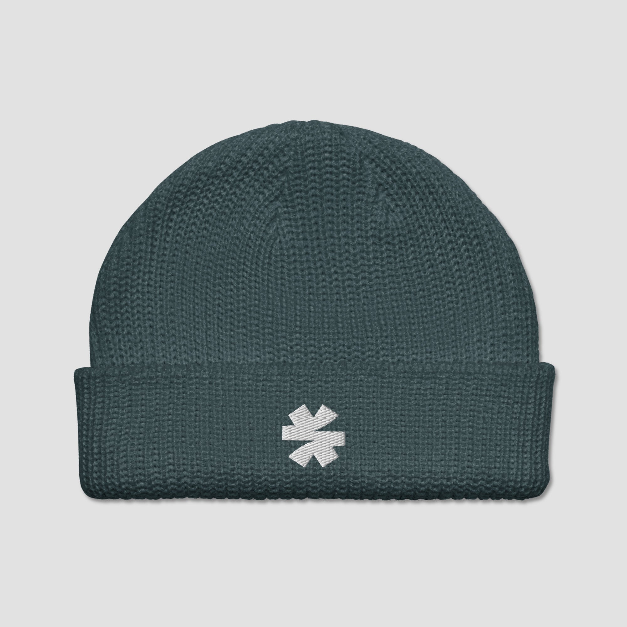 A dark teal ribbed knit beanie hat with a white embroidered asterisk logo on the front cuff, shown against a light gray background.