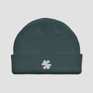 A dark teal ribbed knit beanie hat with a white embroidered asterisk logo on the front cuff, shown against a light gray background.