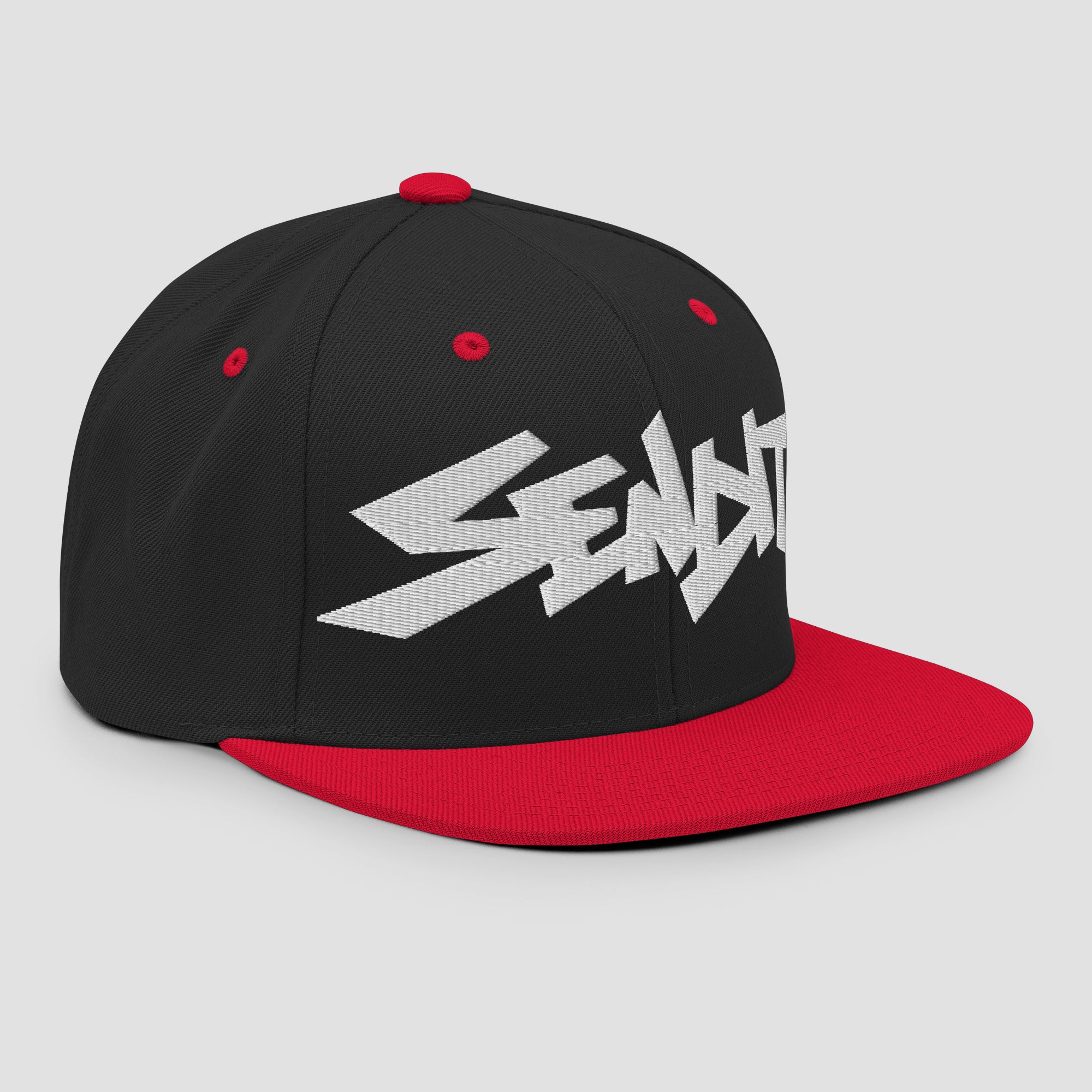 A black and red snapback cap featuring a stylized white embroidered 'SENDIT' logo on the front panel, set against a light gray background.