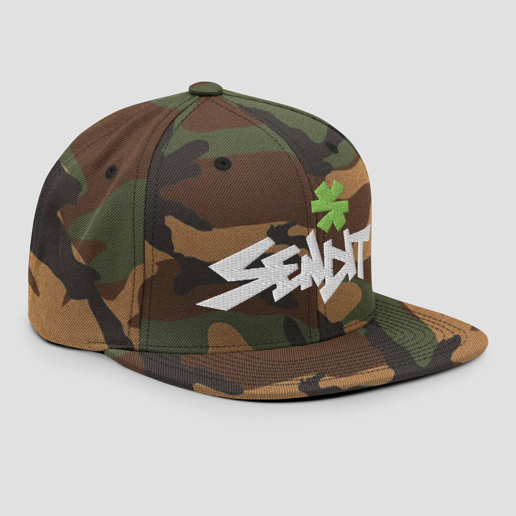 A camouflage flat-brim cap featuring a green asterisk and the word 'SENDIT' in stylized white lettering on the front, set against a light gray background.