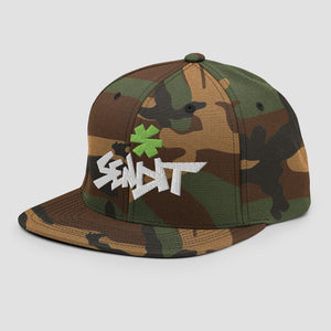 A flat-brim snapback cap in a classic woodland camouflage pattern, featuring a white embroidered 'SENDTT' logo and a green asterisk on the front, set against a plain light gray background.