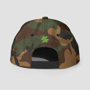 Rear view of a camouflage baseball cap with a green asterisk logo on the back, shown on a light gray background.